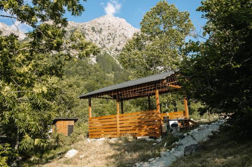 a wooden pavilion with a mountain in the background at Ursa Camp in Gornje Lipovo