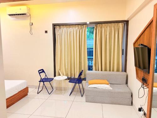 a living room with a couch and a tv at Passiflora Beach Resort Alibaug in Alibaug