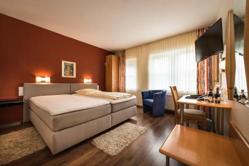 Habitación de hotel con cama y escritorio en Hotel & Gasthaus Nagel en Südlohn
