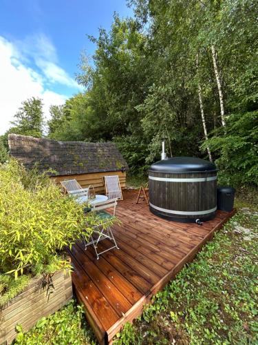 a deck with a hot tub and two chairs on it at Gite Clé des Champs in Montenois