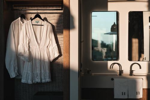 a robe hanging on a wall next to a bathroom sink at Castor & Pollux in Kotrónion
