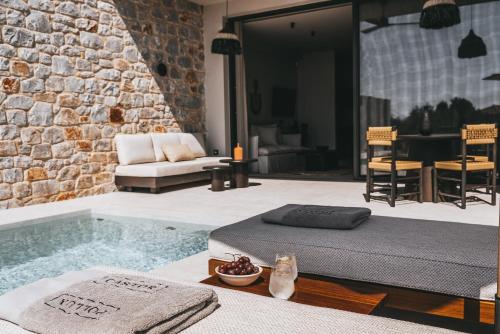 a bedroom with a massage bed and a living room at Castor & Pollux in Kotrónion