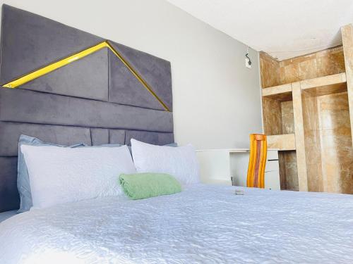 a bedroom with a bed with a green pillow on it at De Mose Family Lodge in KwaZibukwane