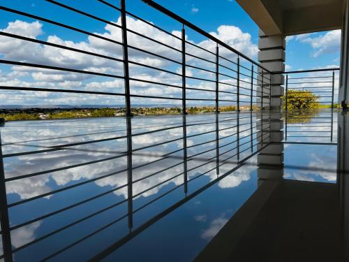 a room with a view of the water through the window at De Mose Family Lodge in KwaZibukwane