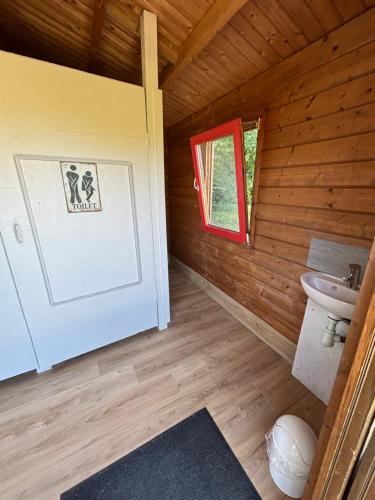 a bathroom with a sink and a window in a log cabin at Gite Clé des Champs in Montenois