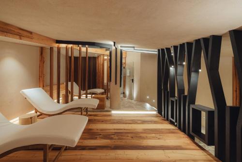 a hallway with white chairs and a table at Hotel Bellavista in Cavalese