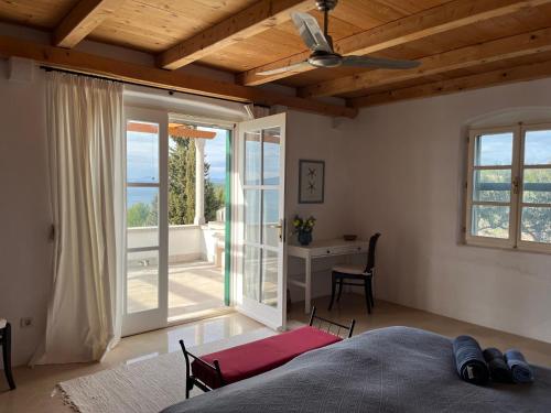 a bedroom with a bed and a desk and windows at Villa Tramonto in Sutivan