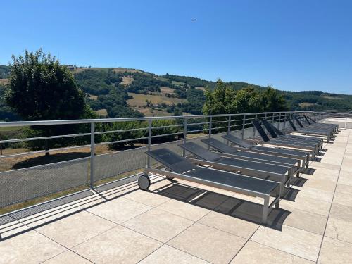 a row of benches sitting on top of a roof at Appartement T2 avec piscine Vallée du Tarn in Trébas