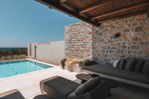 a villa with a swimming pool with a couch and chairs at Castor & Pollux in Kotrónion