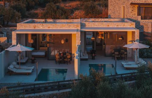 a villa with a swimming pool with umbrellas at Castor & Pollux in Kotrónion