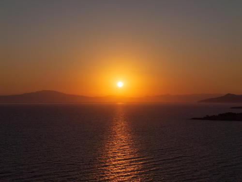 a sunset over the ocean with the sun in the sky at Castor & Pollux in Kotrónion