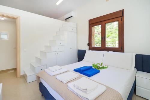 una camera da letto con un letto bianco con asciugamani sopra di Blue Dream Villa a Nea Skioni