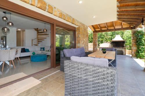 un patio con un divano, un tavolo e un soggiorno di Blue Dream Villa a Nea Skioni