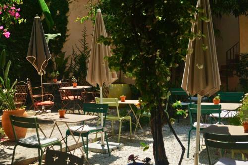 an outdoor patio with tables and chairs and umbrellas at Hotel Can Abril in Sóller