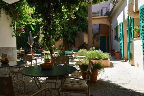 an outdoor patio with tables and chairs and plants at Hotel Can Abril in Sóller