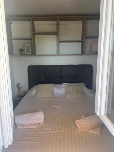 a bed with two towels on it in a room at Mobile home La Bella in Drage