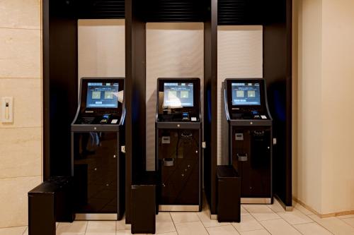 a row of three arcade machines in a room at Richmond Hotel Akita Ekimae in Akita