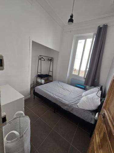 une chambre avec un lit et une fenêtre dans l'établissement Charmant T3 à Marseille-Joliette, à Marseille