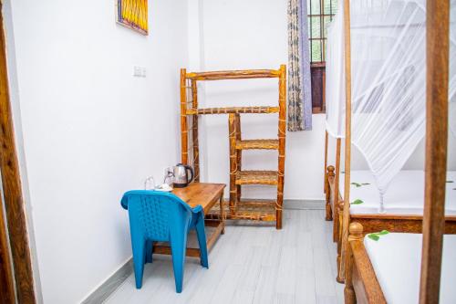 a room with a wooden table and a blue chair at Amazing Beach Hotel Zanzibar in Nungwi
