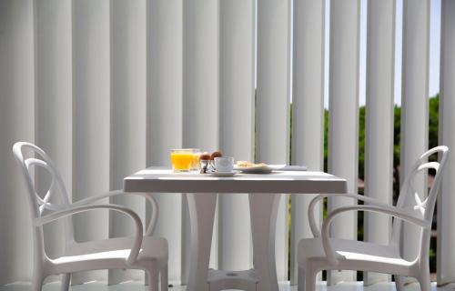 a white table with two chairs and a plate of food at The One Hotel - Designed for Adults - Pet lovers in Riccione