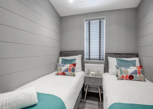 two beds in a small room with a window at V28 - The Lookout with Hot Tub in Bethesda