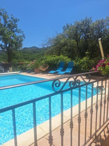 une piscine avec deux chaises bleues sur un balcon dans l'établissement Lou paradiú du verdon, à Allemagne-en-Provence