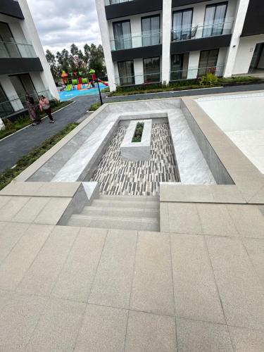 a bench in the middle of a sidewalk in front of a building at TheEJResidence- 2Bedroom All Ensuite- 7km from JKIA 3km from SGR and Expressway along Mombasa Road-Nairobi Kenya in Nairobi