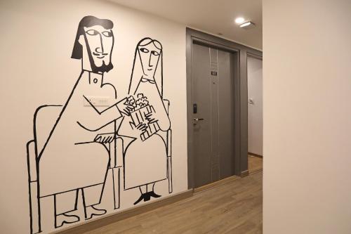 a drawing of two people sitting on chairs in a hallway at Super Hotel O THE FERN SUITES in Hyderabad