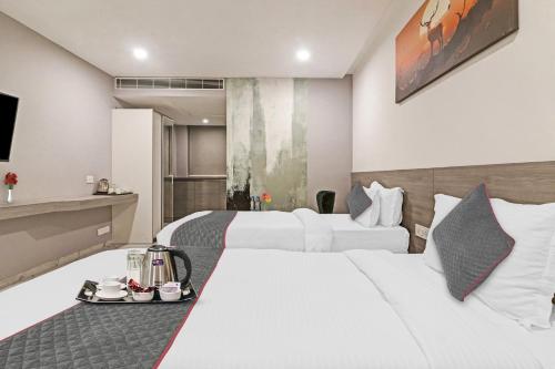 two beds in a hotel room with a tray of food at Super Hotel O THE FERN SUITES in Hyderabad