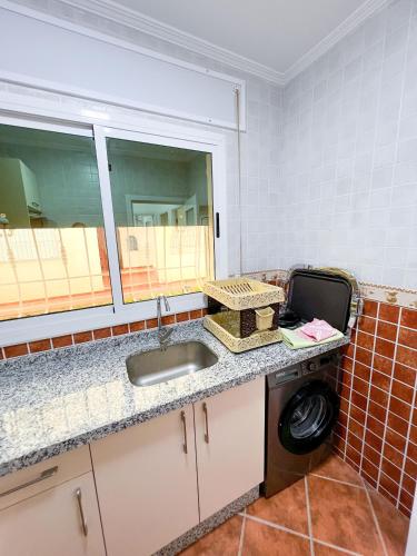 a kitchen with a sink and a washing machine at Appart-hôtel Costa Azul - Cannes in Oued Laou