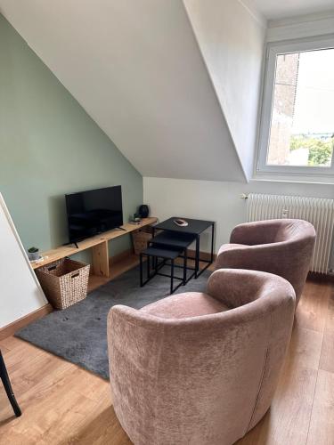 a living room with two chairs and a table at La Loge et La Pause Compiègnoise in Compiègne