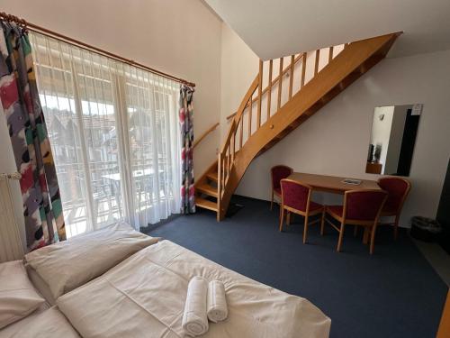a bedroom with a bed and a table and a staircase at Hotel Sonnenhof - Tante ALMA`s Sommerfrische in Sonnen