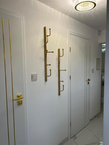 a hallway with white walls and gold fixtures on the wall at GOLD Apartment in Święta Katarzyna