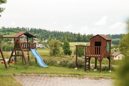 a playground with two swings and a slide at Hotel Sonnenhof - Tante ALMA`s Sommerfrische in Sonnen