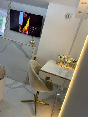 a room with a desk and a chair and a tv at GOLD Apartment in Święta Katarzyna