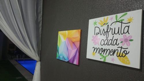 two pictures on a wall with a sign that reads duffelived added memories at Vida no Paraíso Lagoinha in Tigre