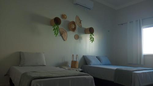 a room with two beds and hats on the wall at Vida no Paraíso Lagoinha in Tigre