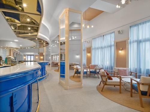 a lobby with a blue counter and tables and chairs at Creta Star Hotel - Adults Only in Skaleta