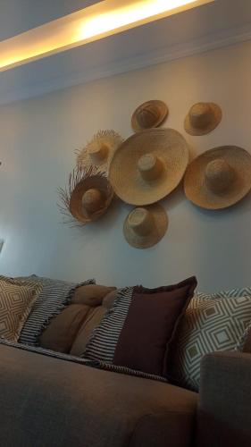a wall with hats on the wall next to a couch at Vida no Paraíso Lagoinha in Tigre