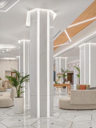 a lobby with white columns and chairs and tables at Creta Star Hotel - Adults Only in Skaleta