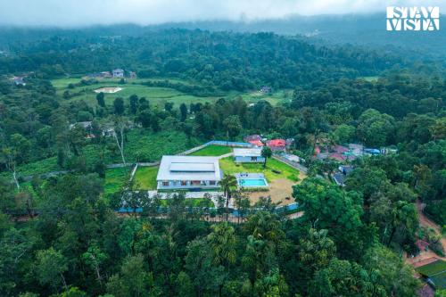 an aerial view of a house in a forest at Serenova 4BR with big pvt pool and lawn - Your escape awaits ! in Madikeri