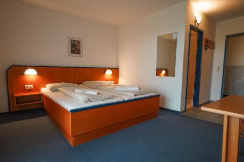 a bedroom with a large bed with white pillows at Hotel Sonnenhof - Tante ALMA`s Sommerfrische in Sonnen