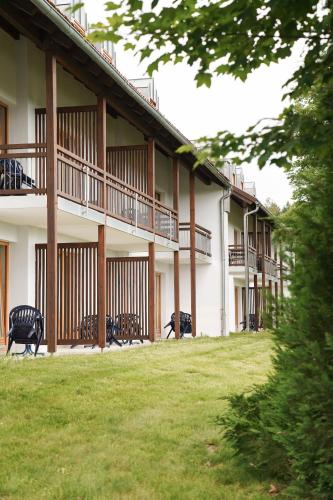 a building with benches in the grass in front of it at Hotel Sonnenhof - Tante ALMA`s Sommerfrische in Sonnen