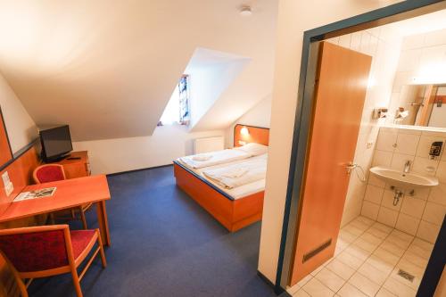 a small room with a bed and a bathroom at Hotel Sonnenhof - Tante ALMA`s Sommerfrische in Sonnen
