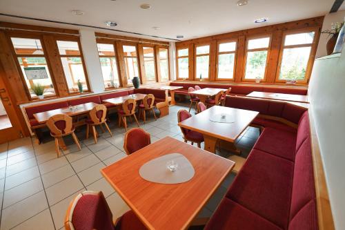 a restaurant with tables and chairs and windows at Hotel Sonnenhof - Tante ALMA`s Sommerfrische in Sonnen