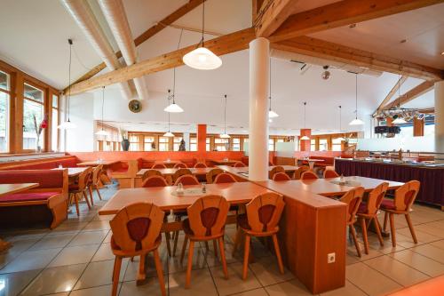 a dining room with wooden tables and chairs at Hotel Sonnenhof - Tante ALMA`s Sommerfrische in Sonnen