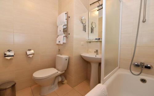 a bathroom with a toilet and a sink and a shower at Готель Дніпро in Kyiv