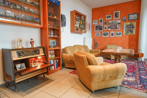 a living room with two chairs and a television at Hotel Sonnenhof - Tante ALMA`s Sommerfrische in Sonnen