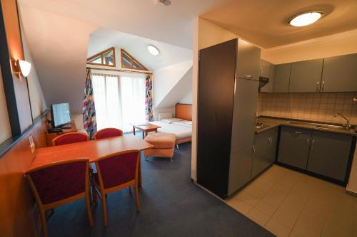 a room with a kitchen and a table and a bed at Hotel Sonnenhof - Tante ALMA`s Sommerfrische in Sonnen