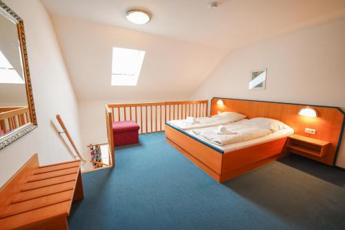a bedroom with a bed and a chair in it at Hotel Sonnenhof - Tante ALMA`s Sommerfrische in Sonnen